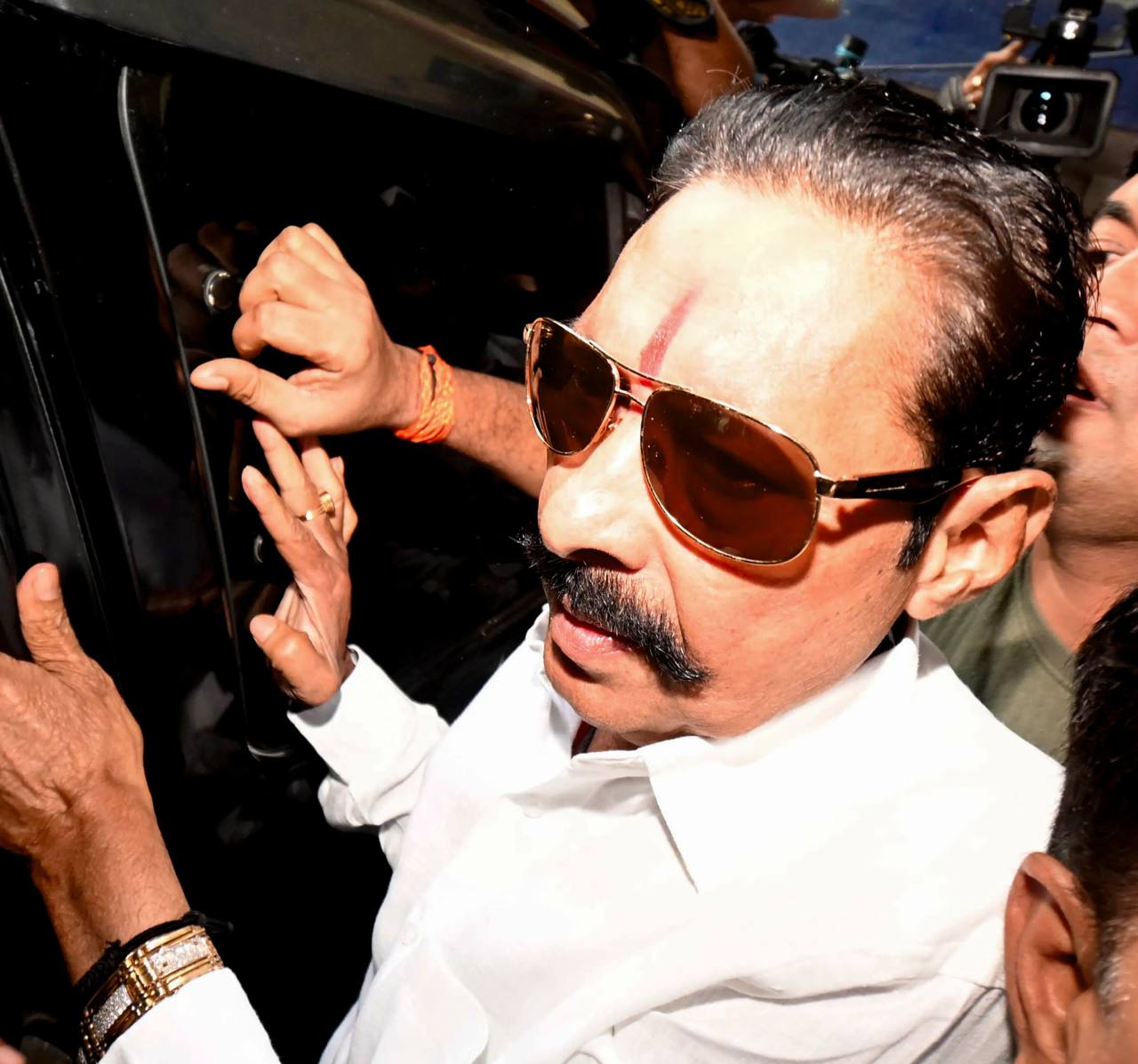 File photo of Mokama MLA Anant Singh in a white kurta and sunglasses, getting into a vehicle amid a crowd