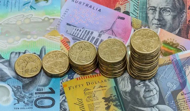 Australian banknotes and stacks of one-dollar coins (file photo)