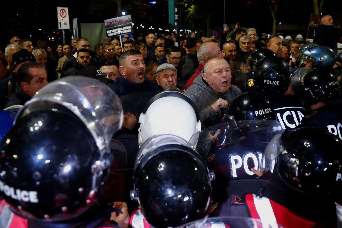 Protesters face a line of riot police at night in central Tirana, Albania