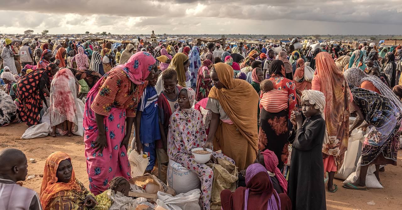 Displaced Sudanese women and children at an aid distribution in a camp (file photo)