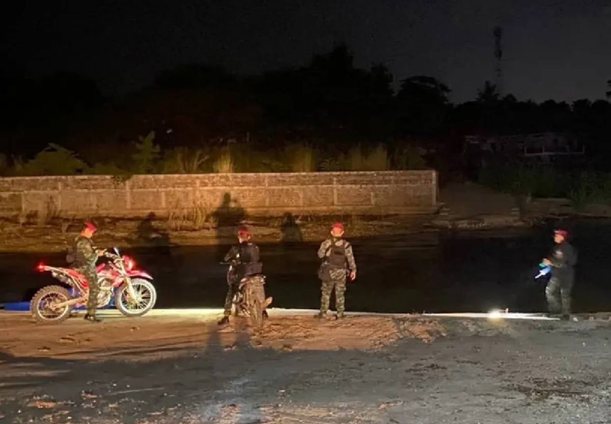Thai security personnel on night patrol with motorcycles beside the Moei River on the Myanmar border in Tak province
