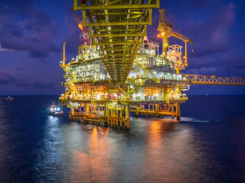 An offshore oil and gas platform lit up at night in the sea (file photo)