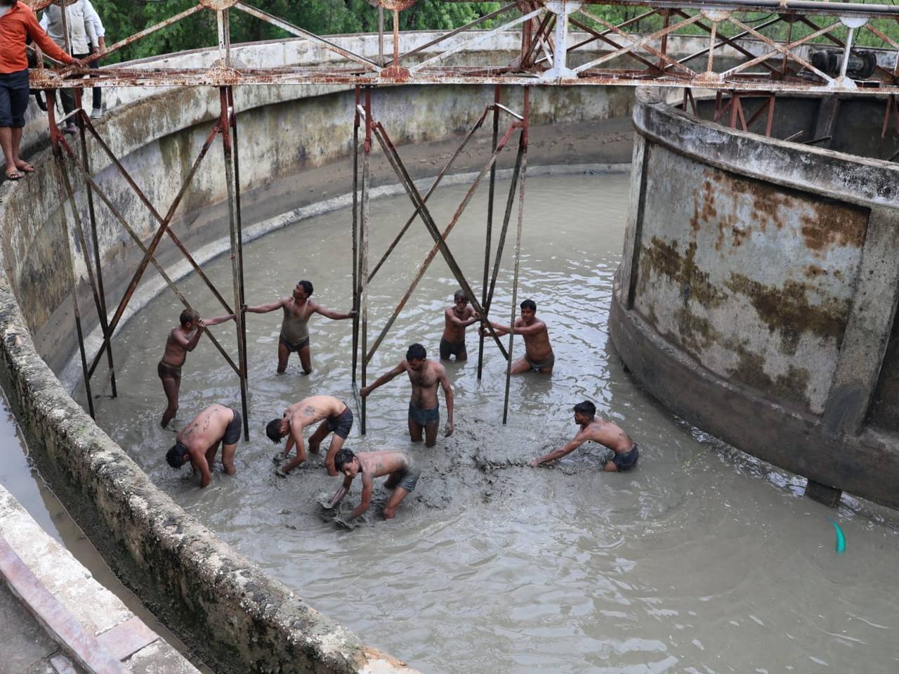 Workers cleaning a water filter plant in Haryana