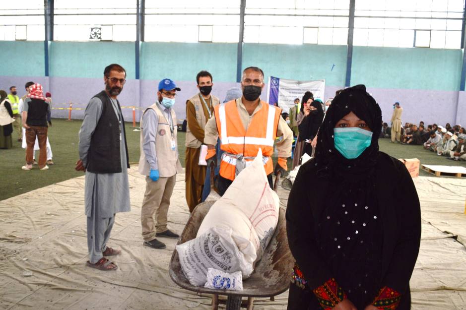 Afghanistan (file photo): a woman collects World Food Programme flour sacks at a food aid distribution point
