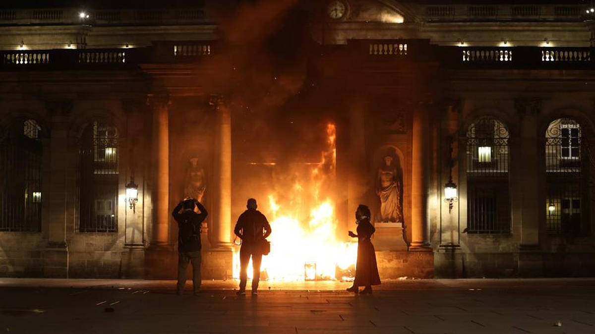 Flames burn at the entrance of a public building in France during night-time protests