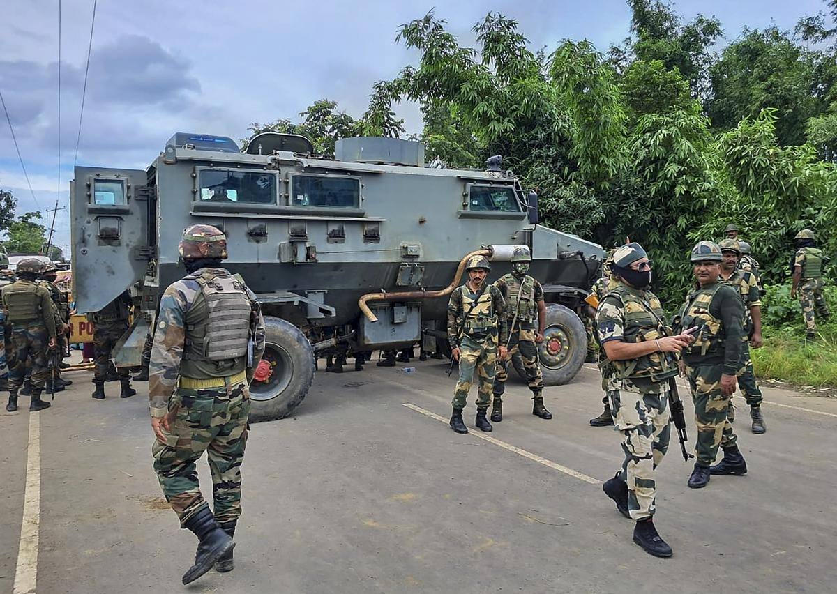 File photo: security forces personnel with an armoured vehicle on a road in Manipur