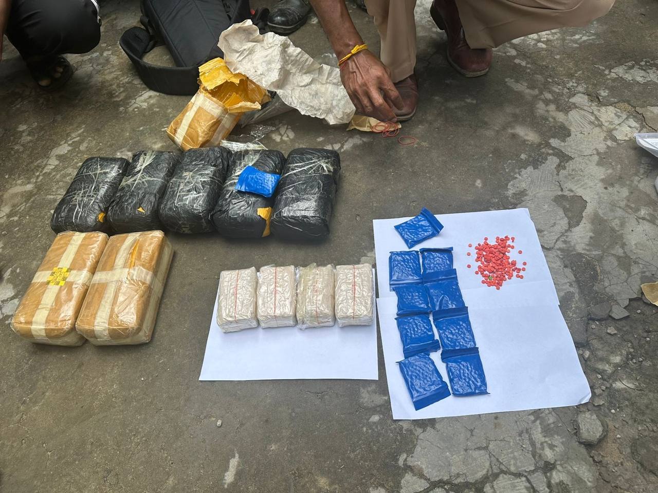 Seized narcotic packets and pills laid out by police after a raid