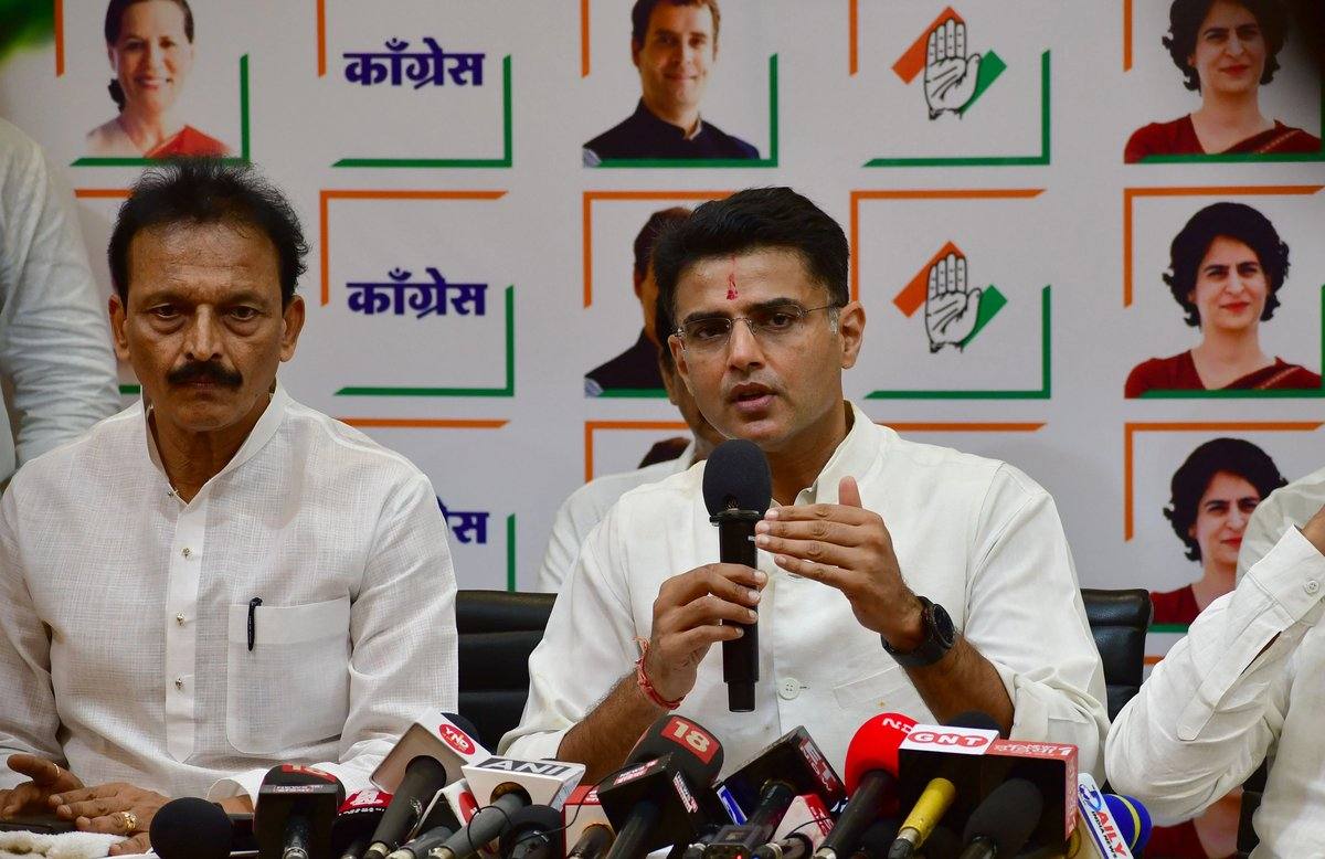 Congress leader Sachin Pilot greeting supporters with folded hands at a crowded street rally
