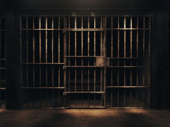 A dark prison cell behind bars