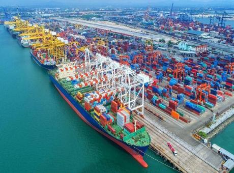 A container ship loaded with export cargo at a busy port