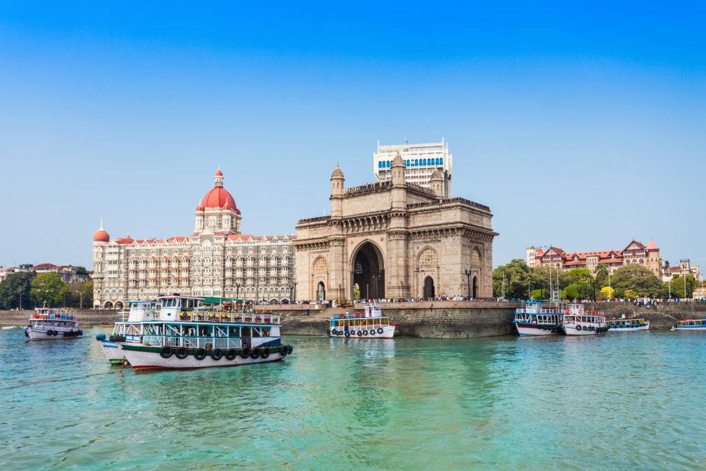 The Gateway of India and the Taj Mahal Palace Hotel seen from Mumbai harbour, with boats in the foreground