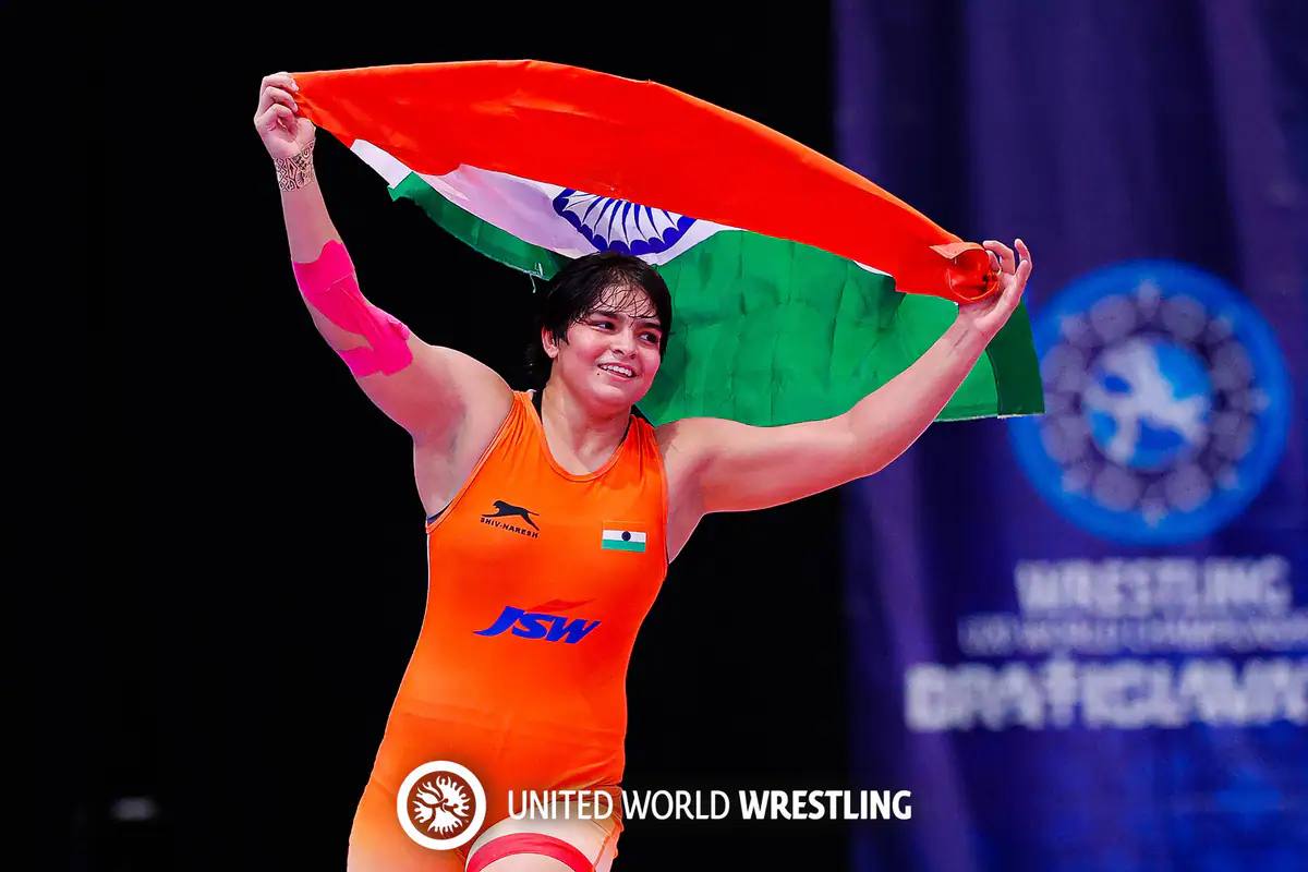 Kajal Dhochak holding the Indian flag overhead after a wrestling title win