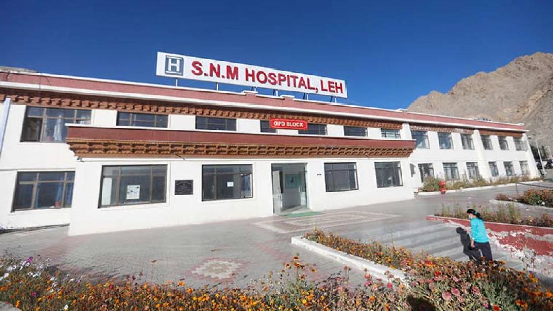 SNM Hospital in Leh, Ladakh, under a clear blue sky with mountains behind it