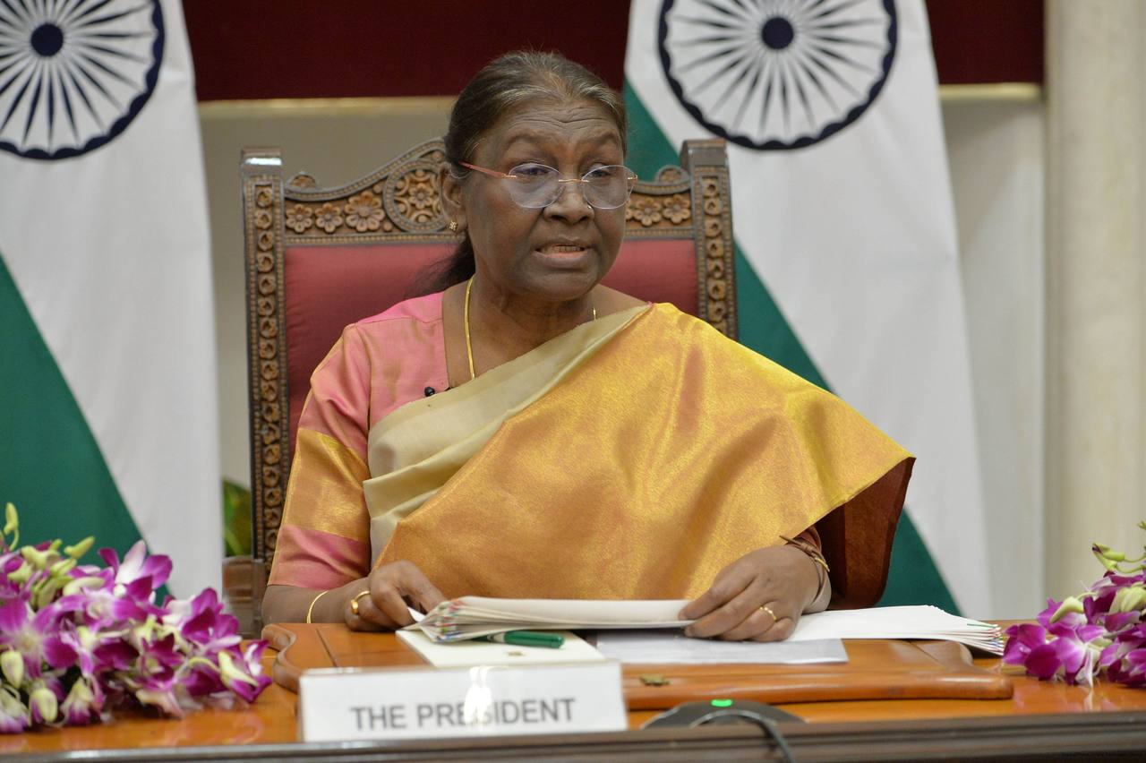 President Droupadi Murmu seated at a desk with the national flag behind her (file photo)