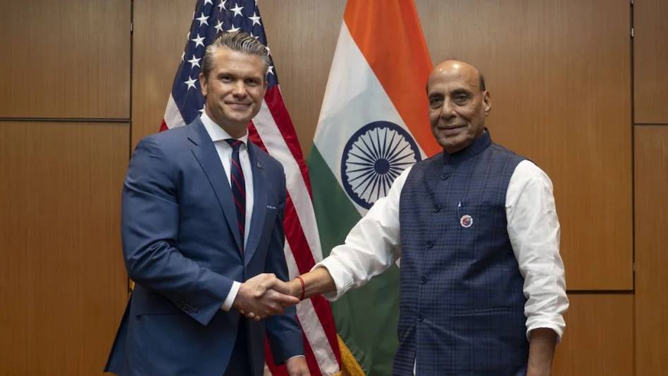 US Secretary of War Pete Hegseth and India's Defence Minister Rajnath Singh shaking hands in front of the US and Indian flags