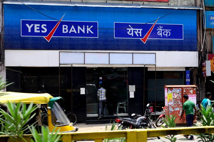 A Yes Bank branch with customers standing at the entrance