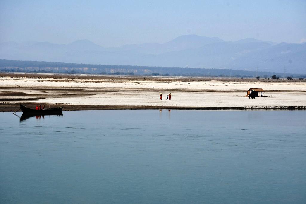 File photo of the wide Saptakoshi river in eastern Nepal, with a small boat near the sandy bank and hills in the distance