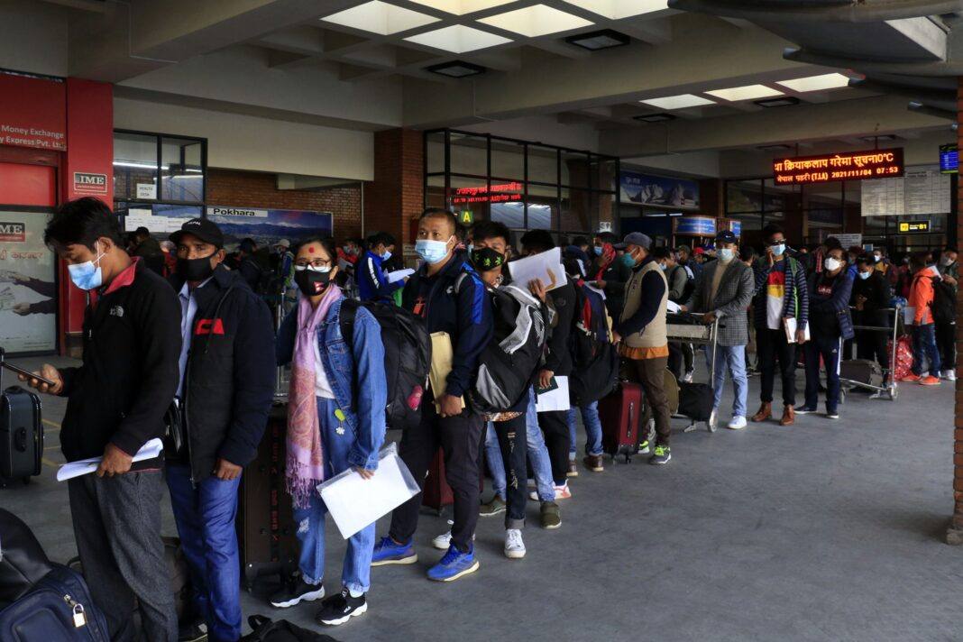 Nepali migrant workers queueing with documents at Kathmandu airport