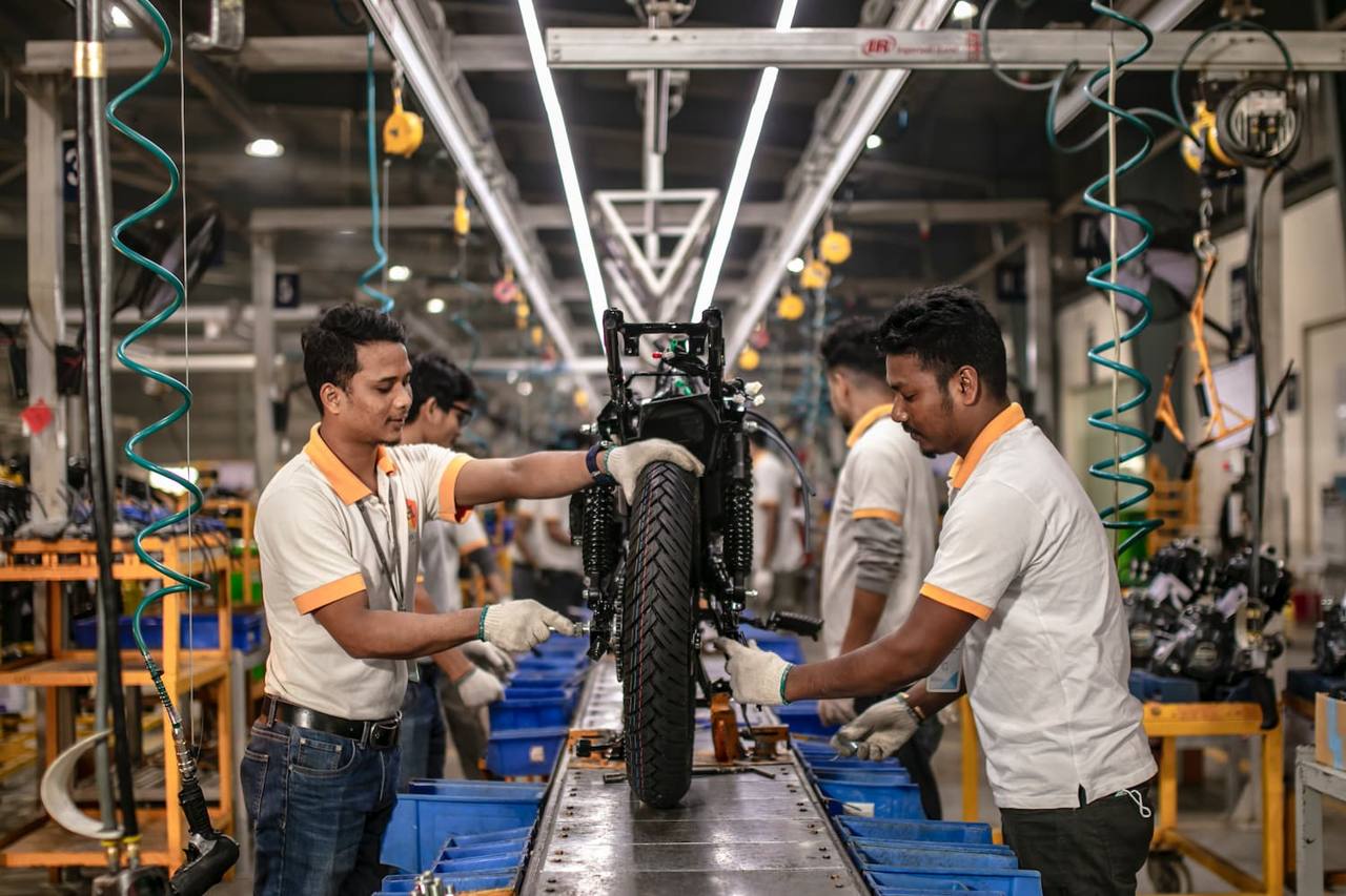 Workers at a vehicle assembly plant in Nepal, with motorcycles on the production line