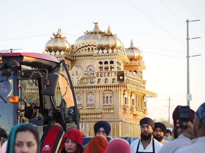Golden decorated float carrying the Sri Guru Granth Sahib through Yuba City during a previous year's Nagar Kirtan procession, with devotees walking alongside