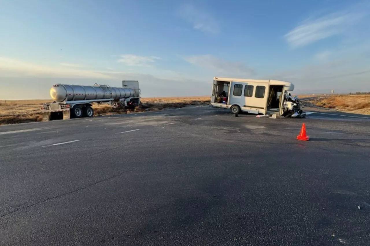 Washington State Patrol photo of the SR 24 crash scene near Othello: a damaged white farmworker bus and a semi tanker truck stopped on a rural two-lane highway in Grant County